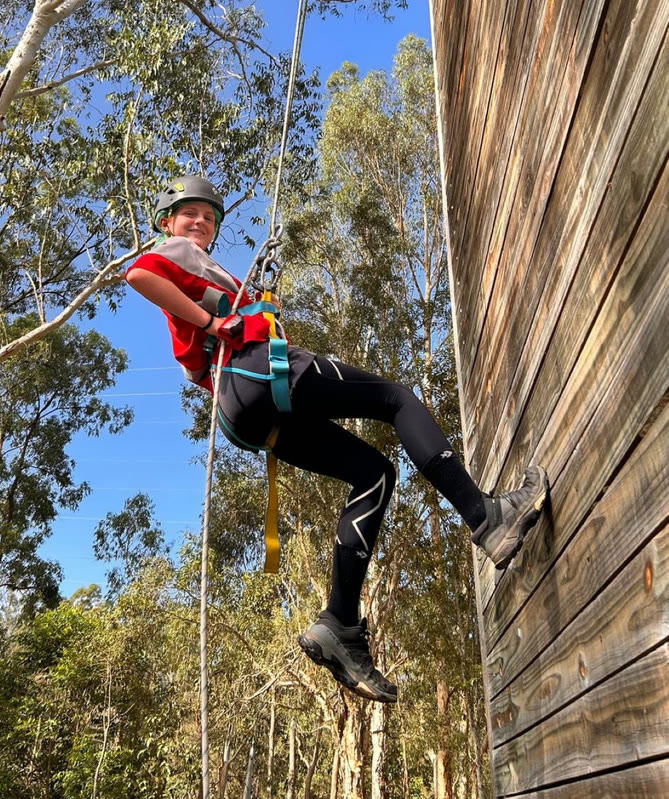 A Scout abseiling down a timber wall